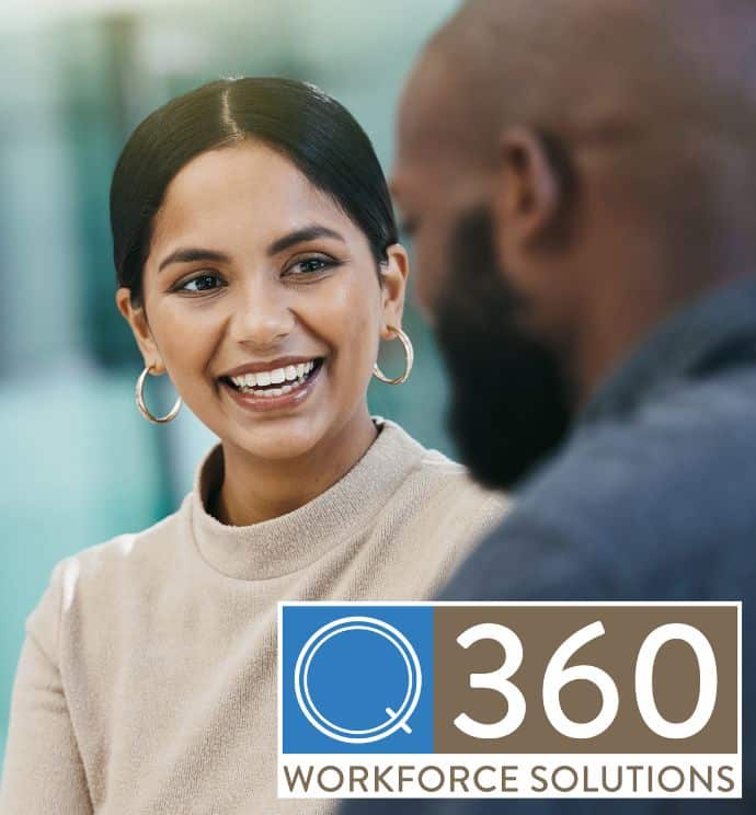 Dark haired woman smiling at a male colleague