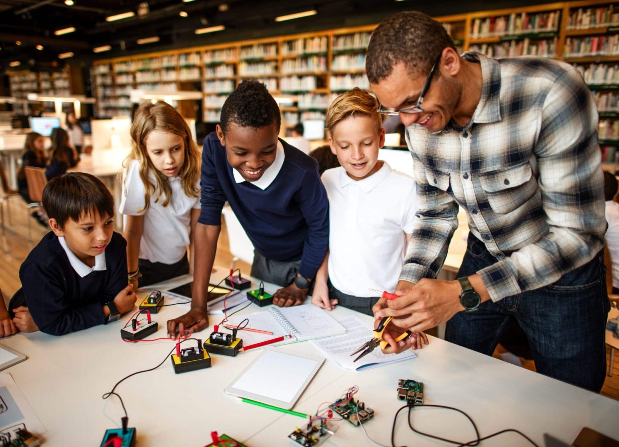 Teacher interacting with students and teaching them about electronics