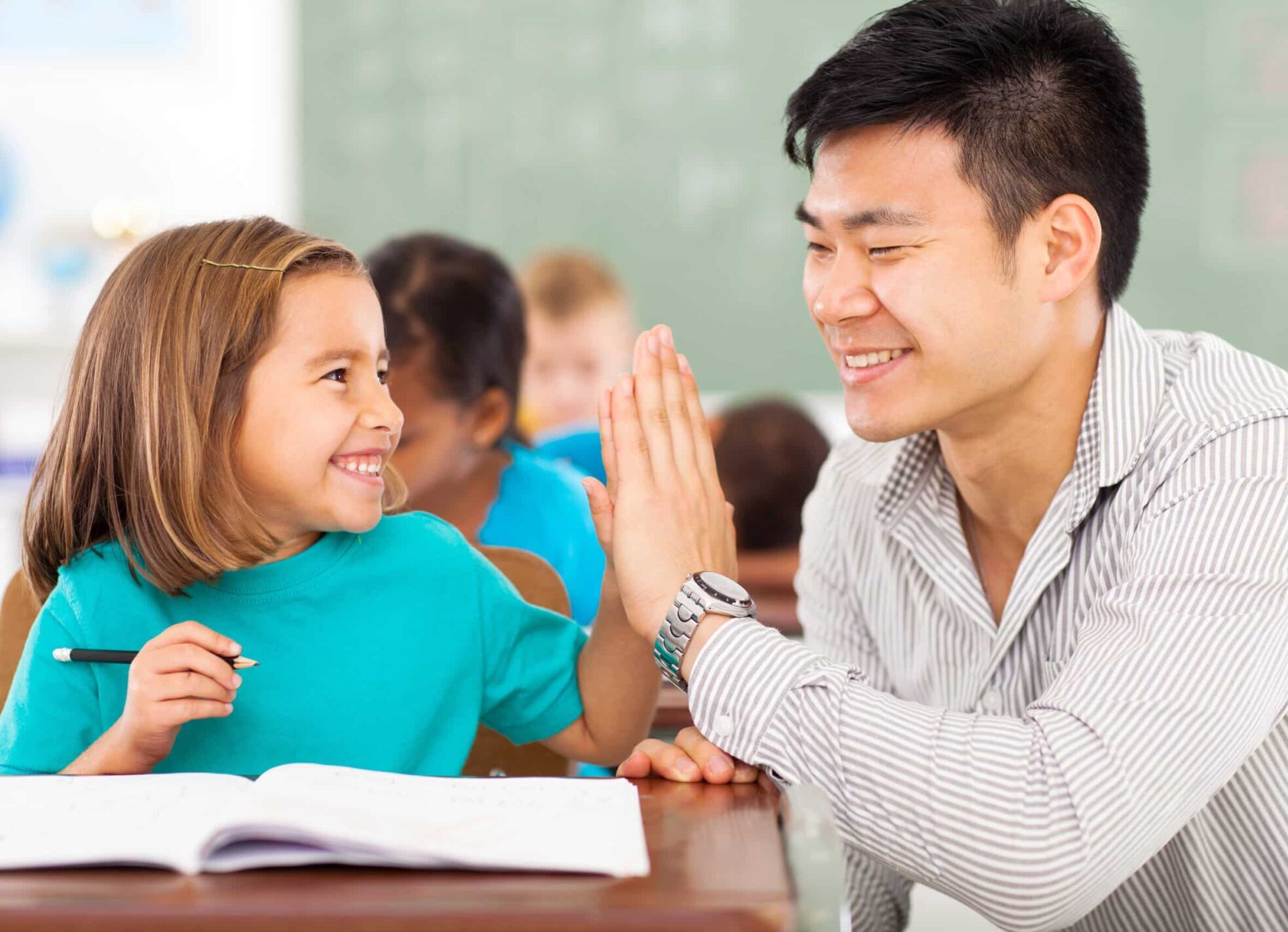 Elementary school teacher giving a high five to a student