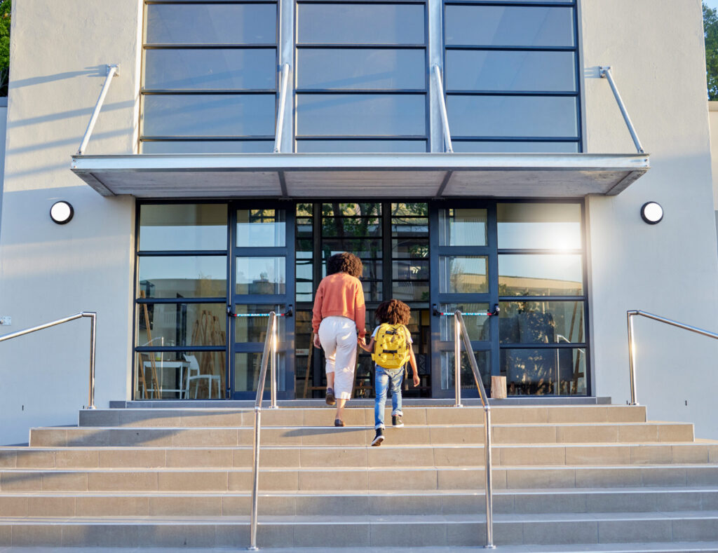 Mother and child walking into school