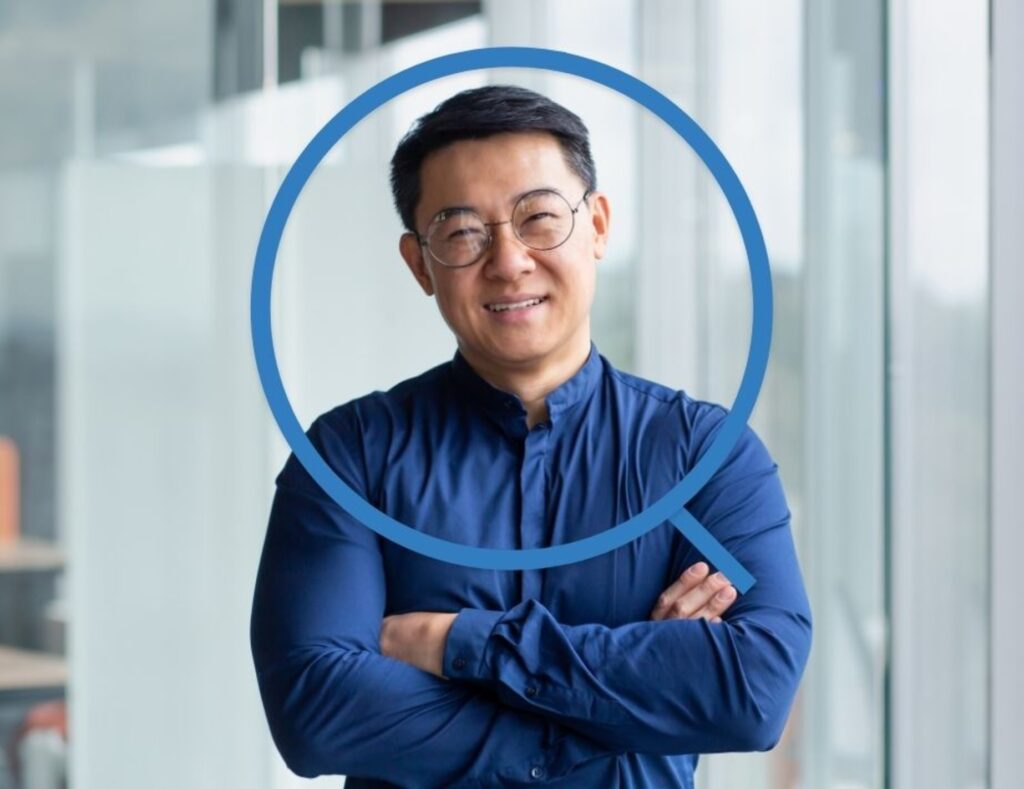 Man in blue smiling with his arms crossed