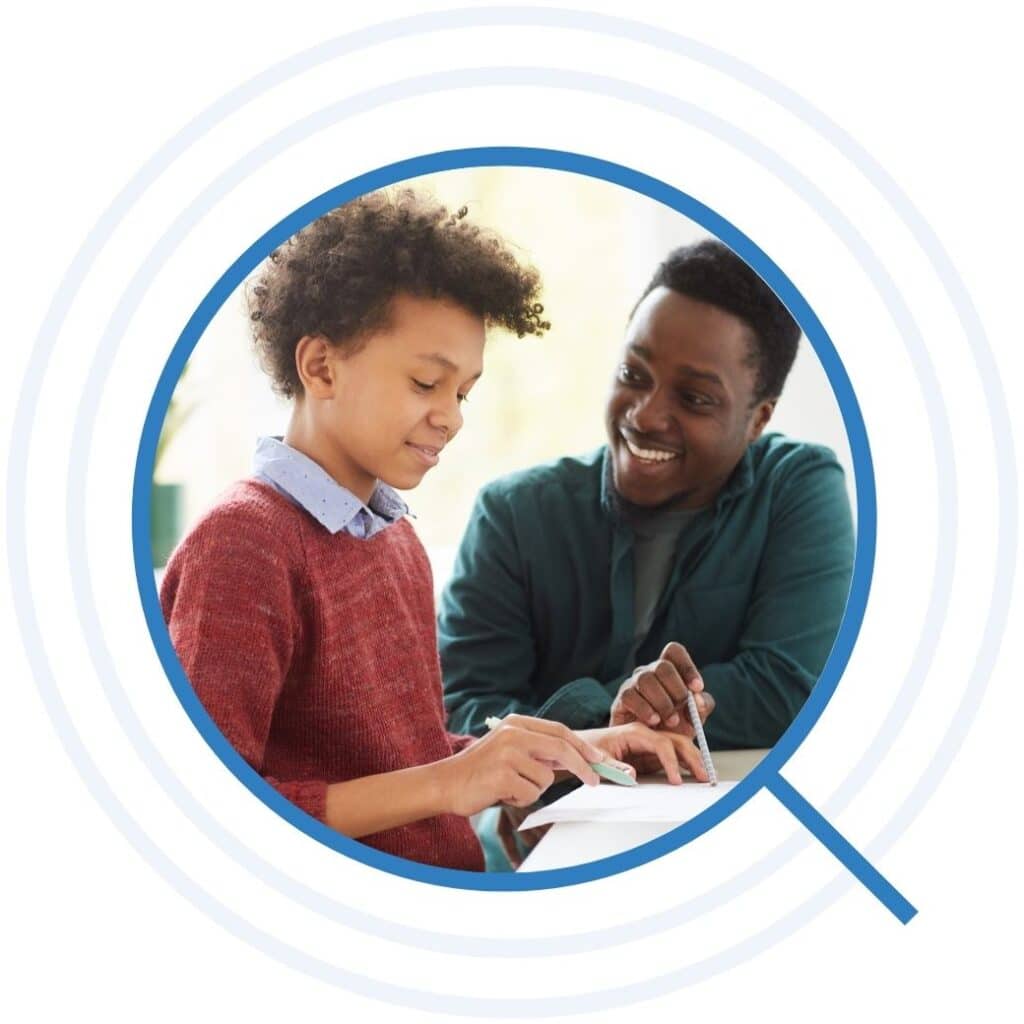 Student and teacher smiling while doing an assignment