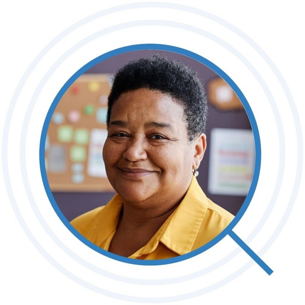 Teacher of nursery school looking at camera while standing against group of little learners