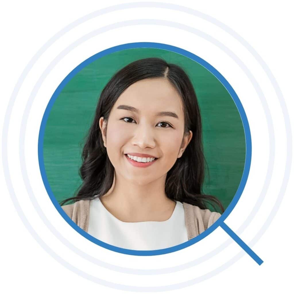 Brunette teacher smiling in front of a chalkboard