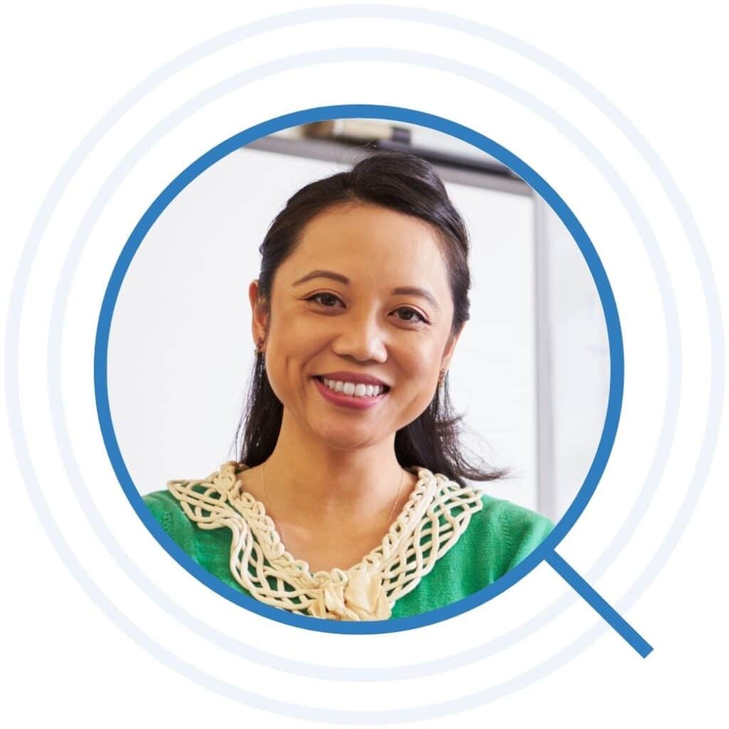 Teacher smiling in front of whiteboard