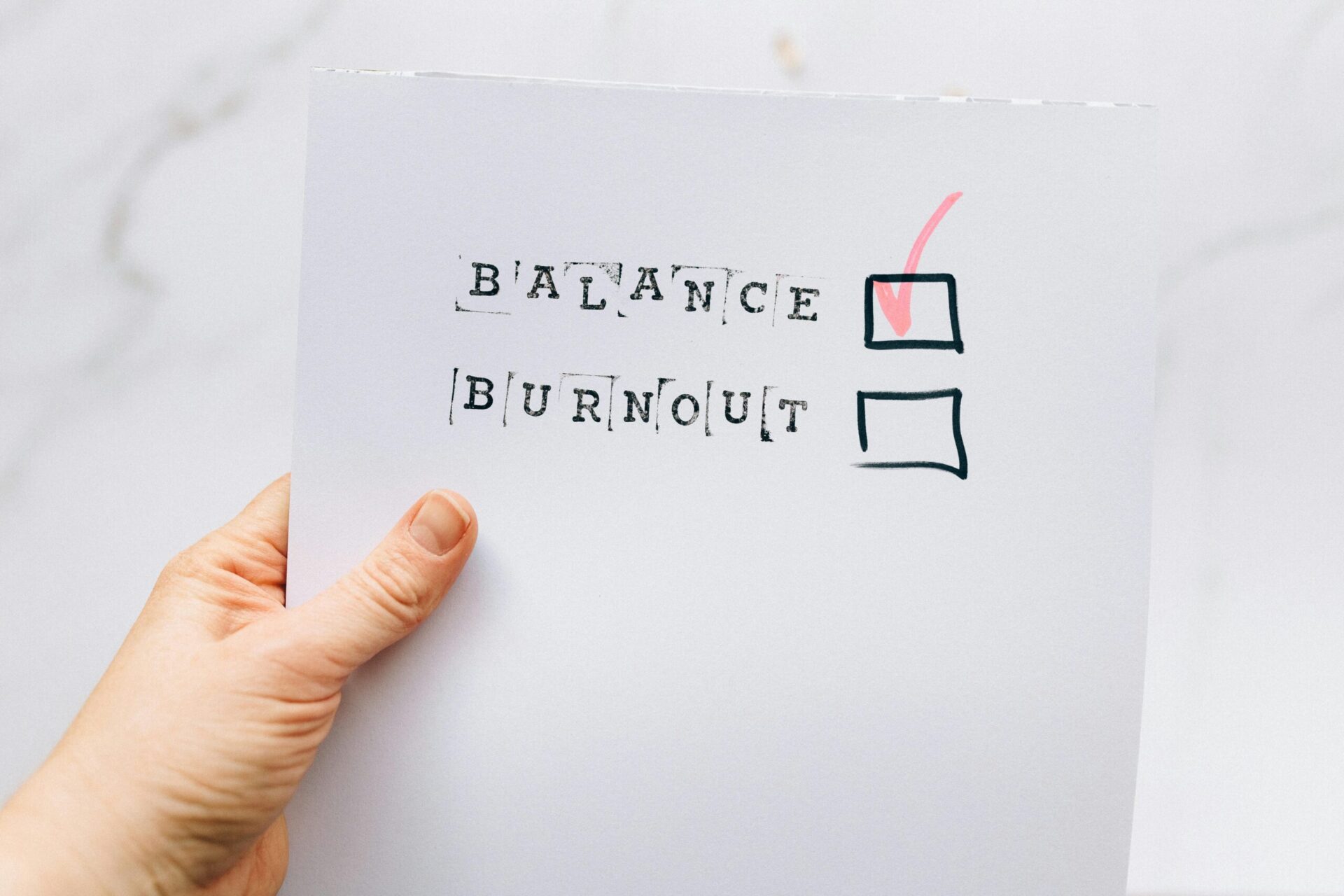 Piece of paper with a checked box next to the word "balance" and an unchecked box next to the word "burnout"