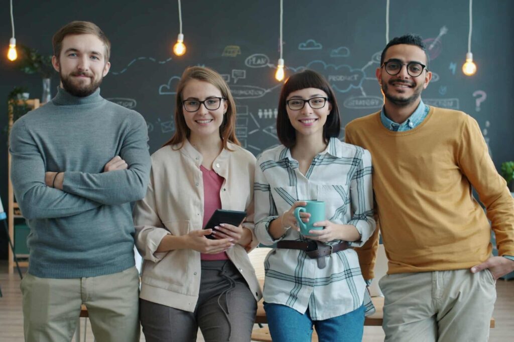 4 teachers standing side-by-side in front of a chalkboard