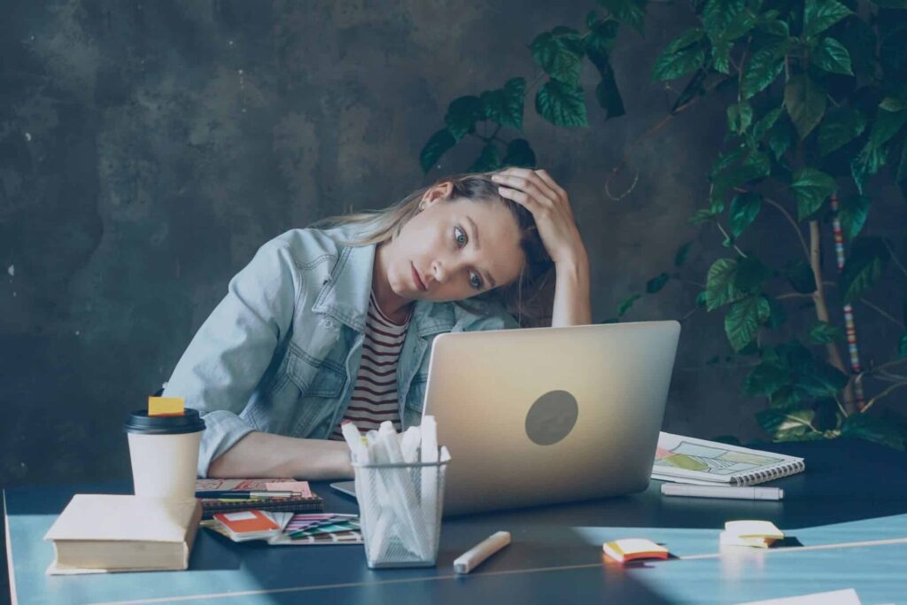 Woman sitting at a laptop looking stressed