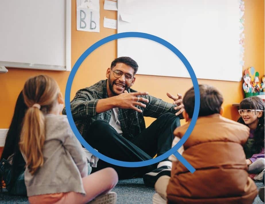 Teacher sitting in a circle on the floor with his students