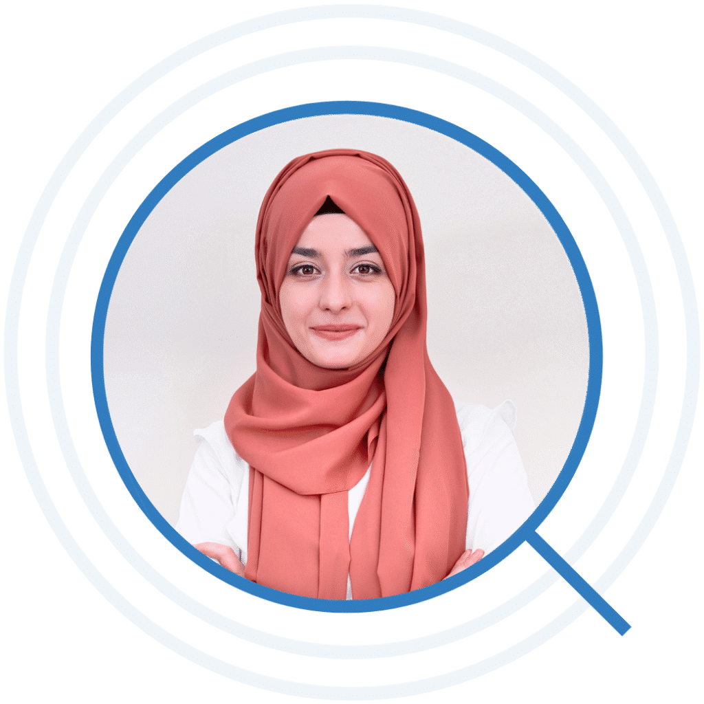 Professional headshot of a smiling woman wearing a coral hijab and white blouse inside a blue circular graphic frame.